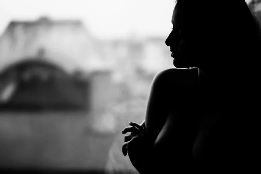 czarno biały portret kobiety na tle okna autor artur sobieraj fotograf